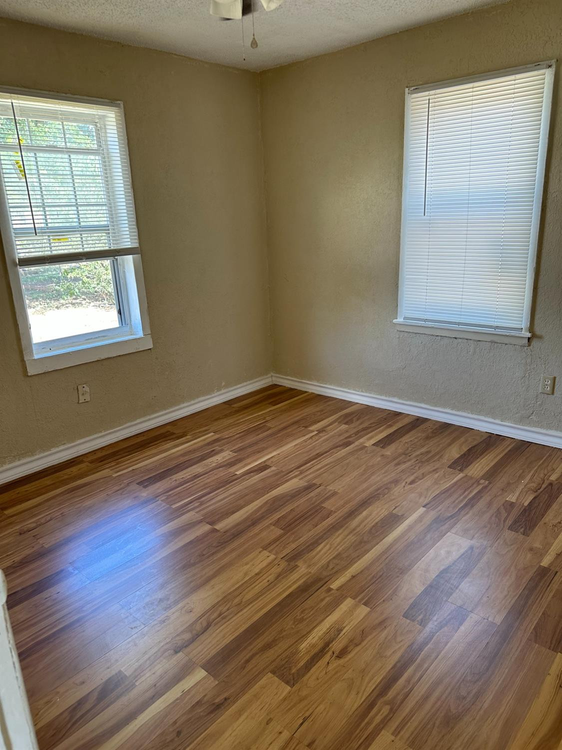 1110 46th Street Lubbock, TX 79412 - Photo 7 of 12 an empty room with wooden floor and windows