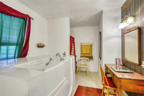 a bathroom with a tub sink and mirror