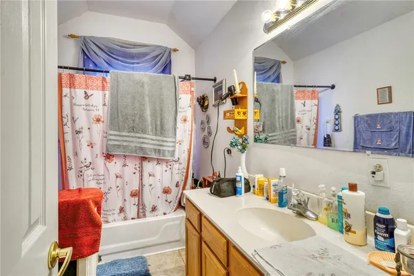 a bathroom with a granite countertop sink and a bathtub