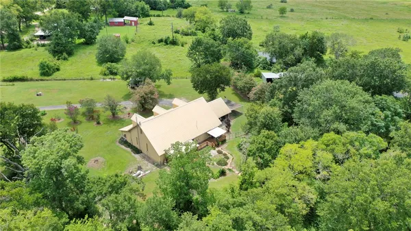 an aerial view of residential house with outdoor space and trees all around