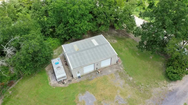 an aerial view of residential houses with outdoor space and trees