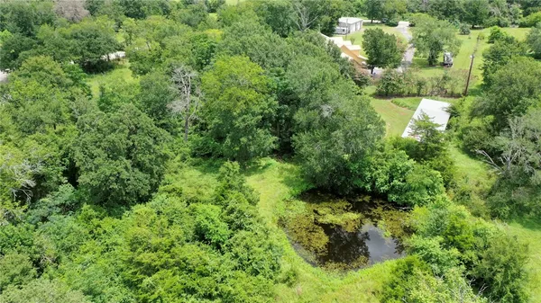 an aerial view of a residential houses with yard and swimming pool