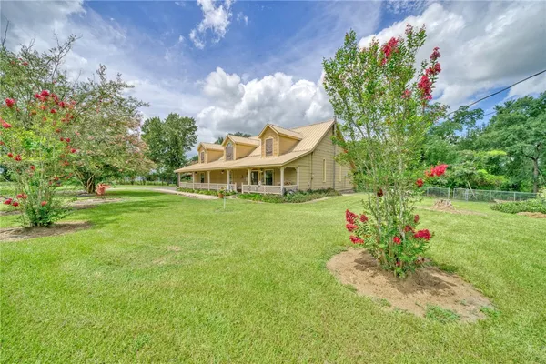 a front view of a house with a big yard and a fountain