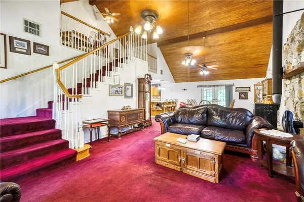 a living room with furniture and a dining table with wooden floor