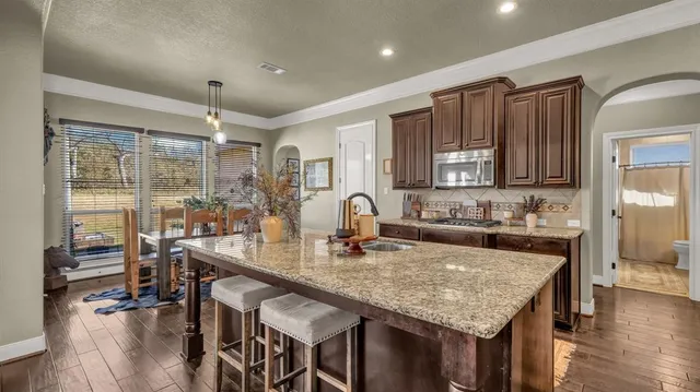 a kitchen with granite countertop kitchen island stainless steel appliances a table and chairs