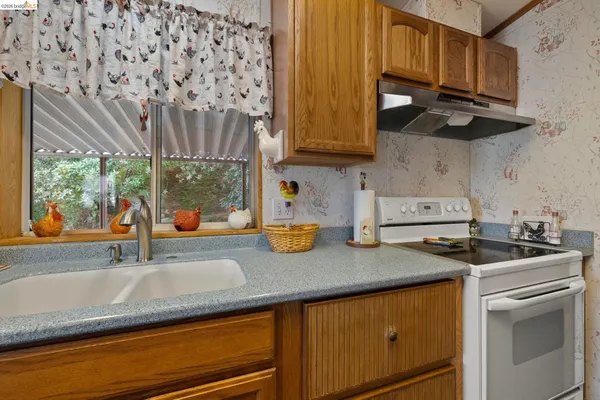 a kitchen with stainless steel appliances granite countertop a sink a stove and cabinets