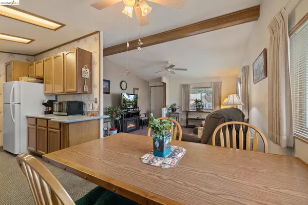 a kitchen with sink refrigerator dining table and chairs