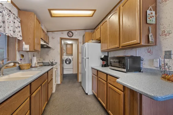 a kitchen with stainless steel appliances granite countertop a sink a stove and a refrigerator