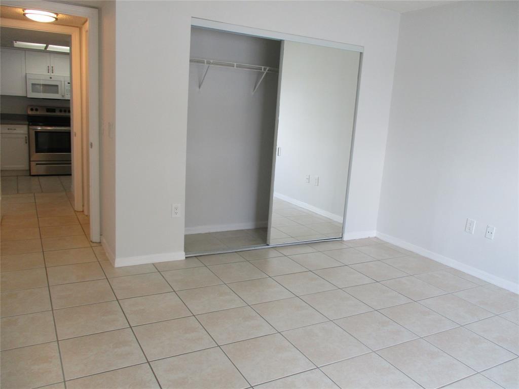 5045 Wiles Road, Unit 206 Coconut Creek, FL 33073 - Photo 15 of 24 an empty room with kitchen