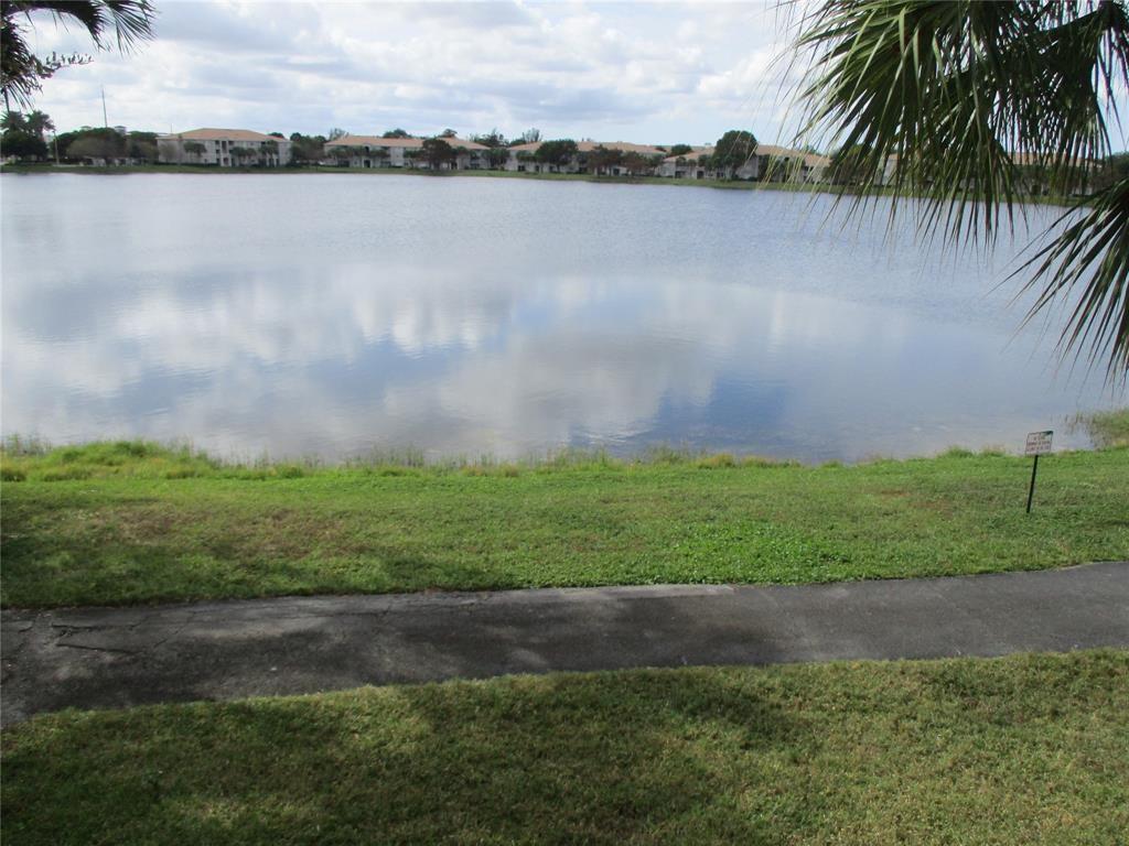 5045 Wiles Road, Unit 206 Coconut Creek, FL 33073 - Photo 21 of 24 a view of a lake with a big yard