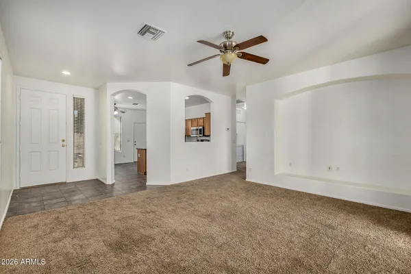an empty room with ceiling fan and window
