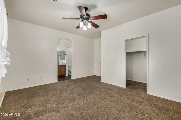 an empty room with a chandelier fan