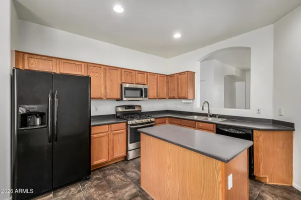 a kitchen with stainless steel appliances granite countertop a refrigerator a sink and a stove