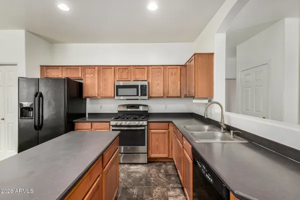 a kitchen with kitchen island granite countertop a stove a sink and a microwave