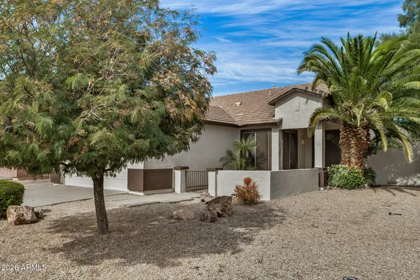 a front view of a house with a tree