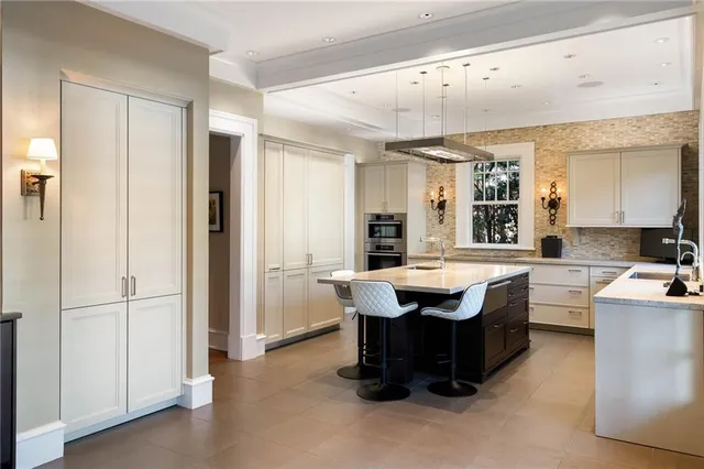 a dining hall with stainless steel appliances granite countertop a refrigerator a sink dishwasher a dining table and chairs with wooden floor