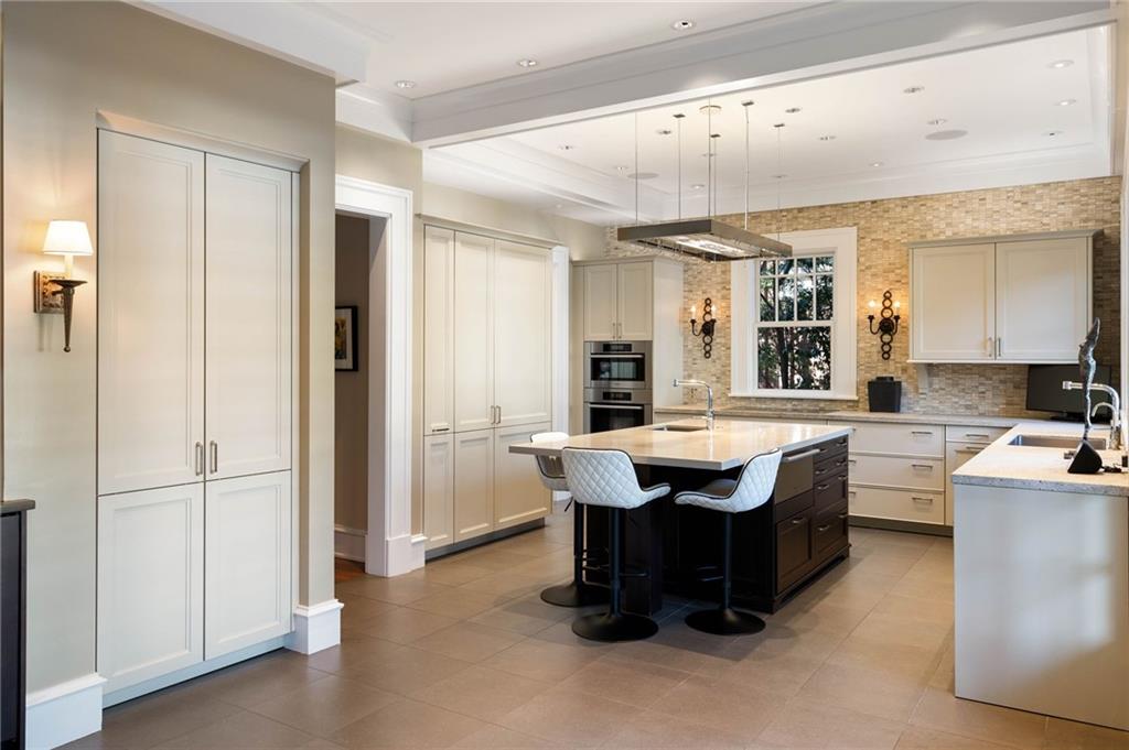 81 Peachtree Circle Northeast Atlanta, GA 30309 - Photo 11 of 54 a dining hall with stainless steel appliances granite countertop a refrigerator a sink dishwasher a dining table and chairs with wooden floor