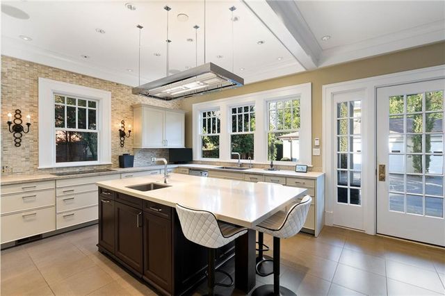 a dining hall with stainless steel appliances granite countertop a stove and a refrigerator