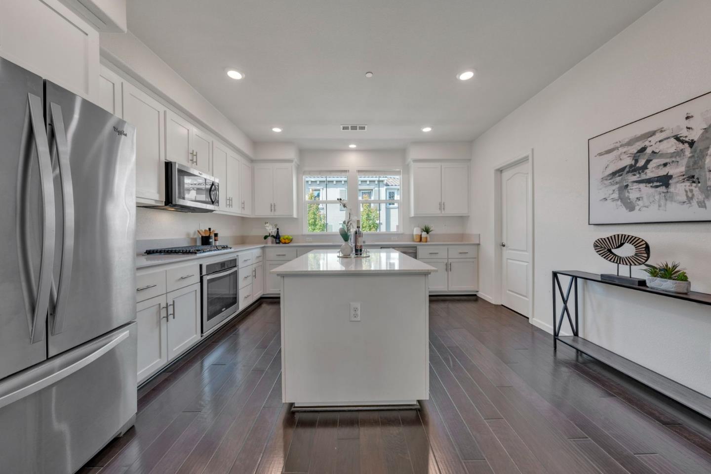 103 Cypress Loop Hayward, CA 94544 - Photo 15 of 55 a kitchen with stainless steel appliances a refrigerator a sink dishwasher a stove and white cabinets with wooden floor