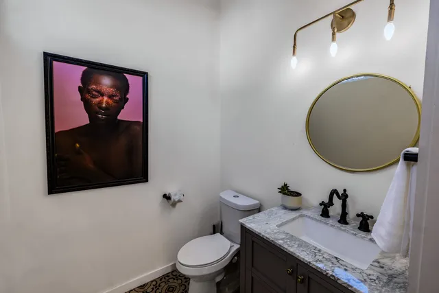 a bathroom with a toilet a sink and mirror