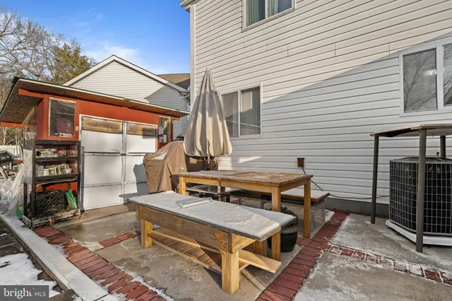 a backyard of a house with barbeque oven table and chairs