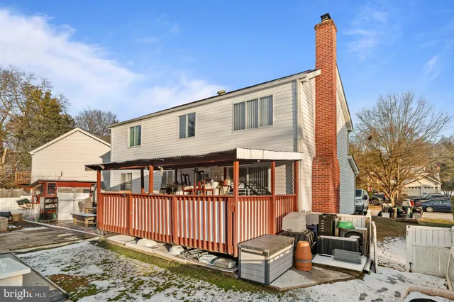 a view of a house with wooden deck and furniture