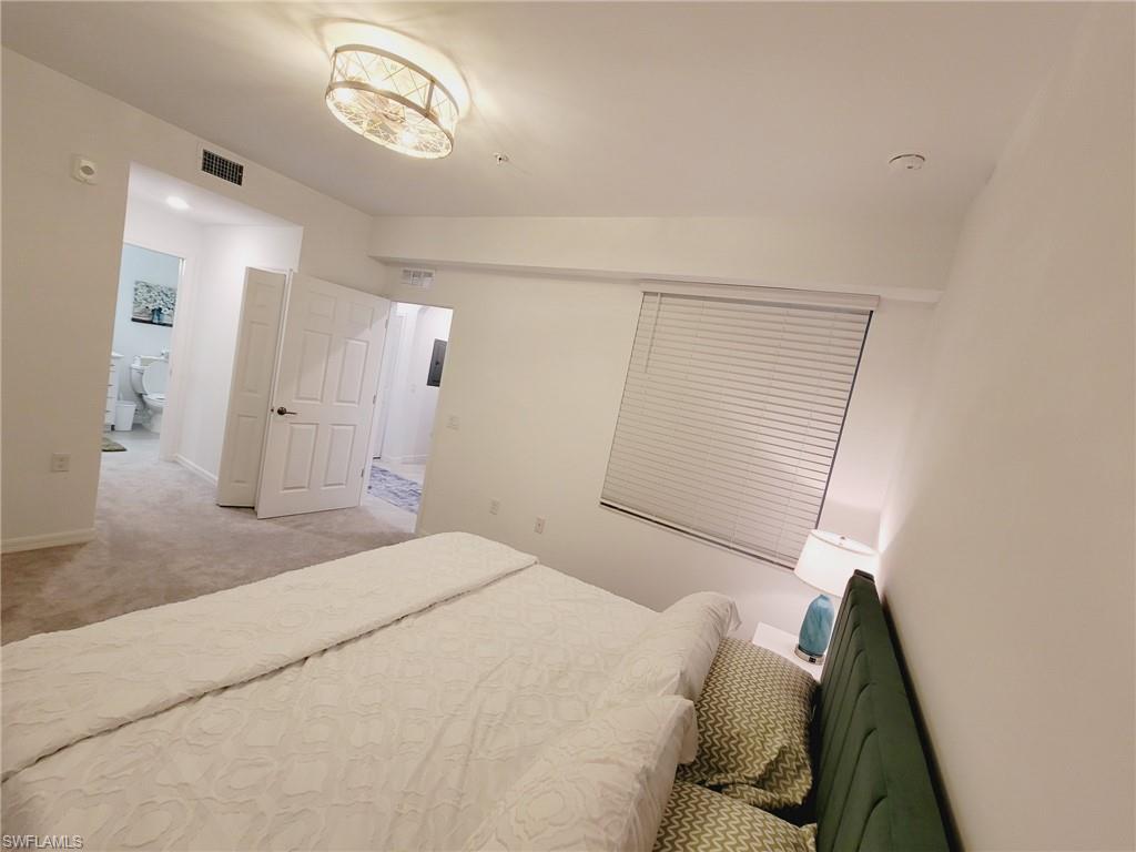 43997 Boardwalk Loop, Unit 1832 Babcock Ranch, FL 33982 - Photo 11 of 22 a bedroom with a bed and a mirror