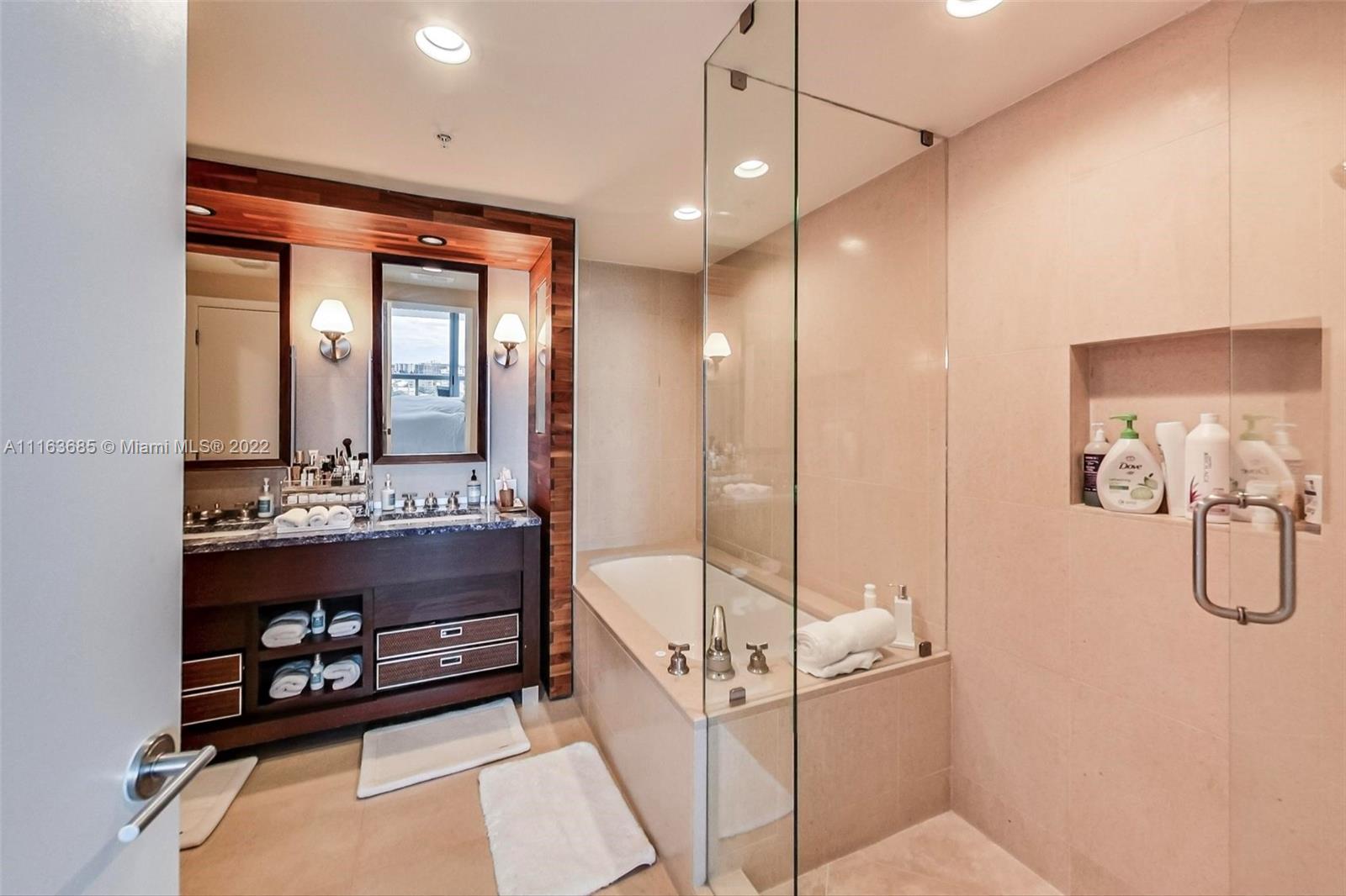 6899 Collins Avenue, Unit 910 Miami Beach, FL 33141 - Photo 18 of 46 a bathroom with a double vanity sink and mirror