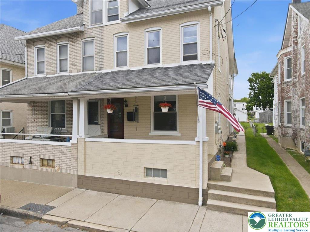 This charming residence features a welcoming front porch and classic brick detailing.
