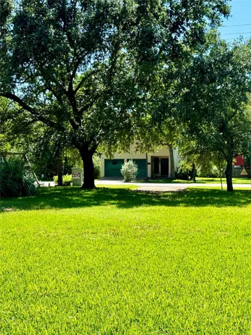 a view of a green field with trees in the background