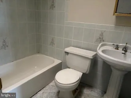 a white toilet sitting next to a bath tub
