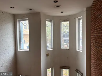 a view of an empty room with windows and closet