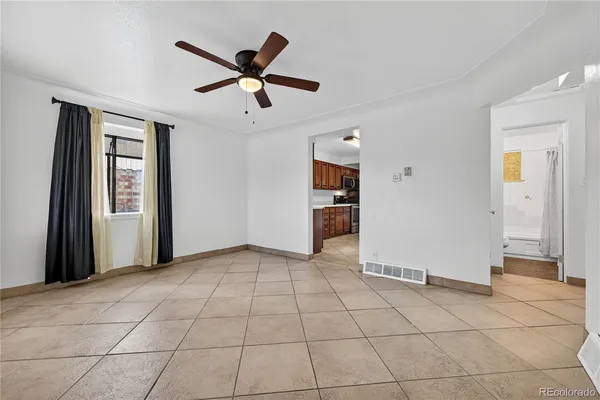 a view of a livingroom with a ceiling fan & windows