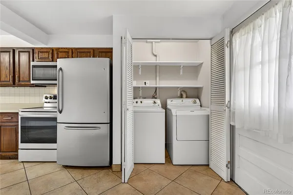 a white refrigerator freezer and a stove sitting inside of a kitchen