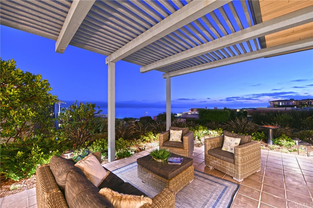 408 Monarch Bay Drive Dana Point, CA 92629 - Photo 26 of 42 a view of a patio with couches chairs dining table and chairs with wooden floor and fence