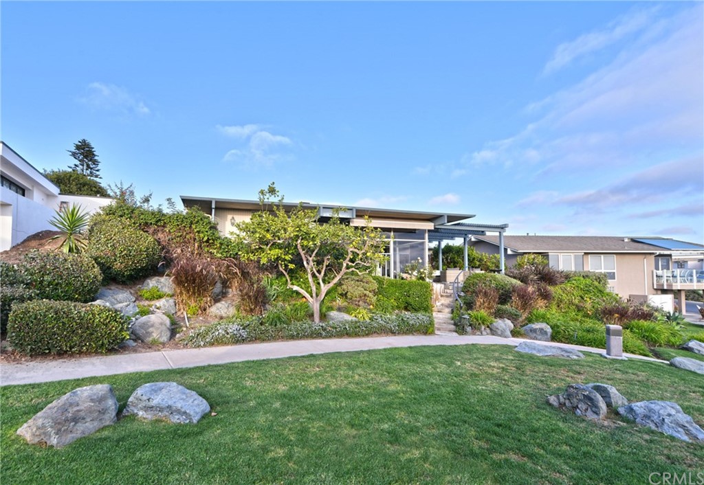 408 Monarch Bay Drive Dana Point, CA 92629 - Photo 32 of 42 a view of a garden with a building in the background