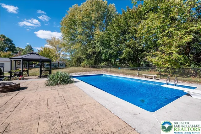 a view of swimming pool in the backyard of house along with seating space