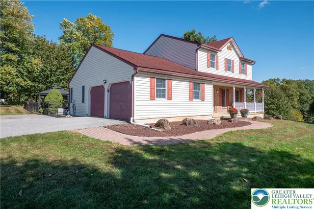 a front view of a house with yard and green space