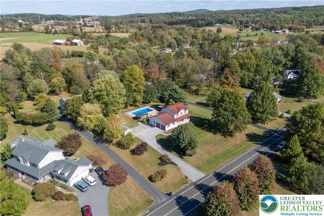 an aerial view of a house with a yard and lake view