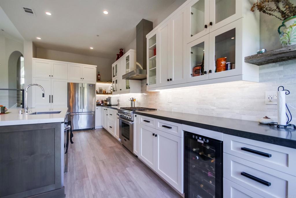 864 Del Mar Downs Road Solana Beach, CA 92075 - Photo 8 of 20 a kitchen with stainless steel appliances granite countertop a sink a stove and a refrigerator