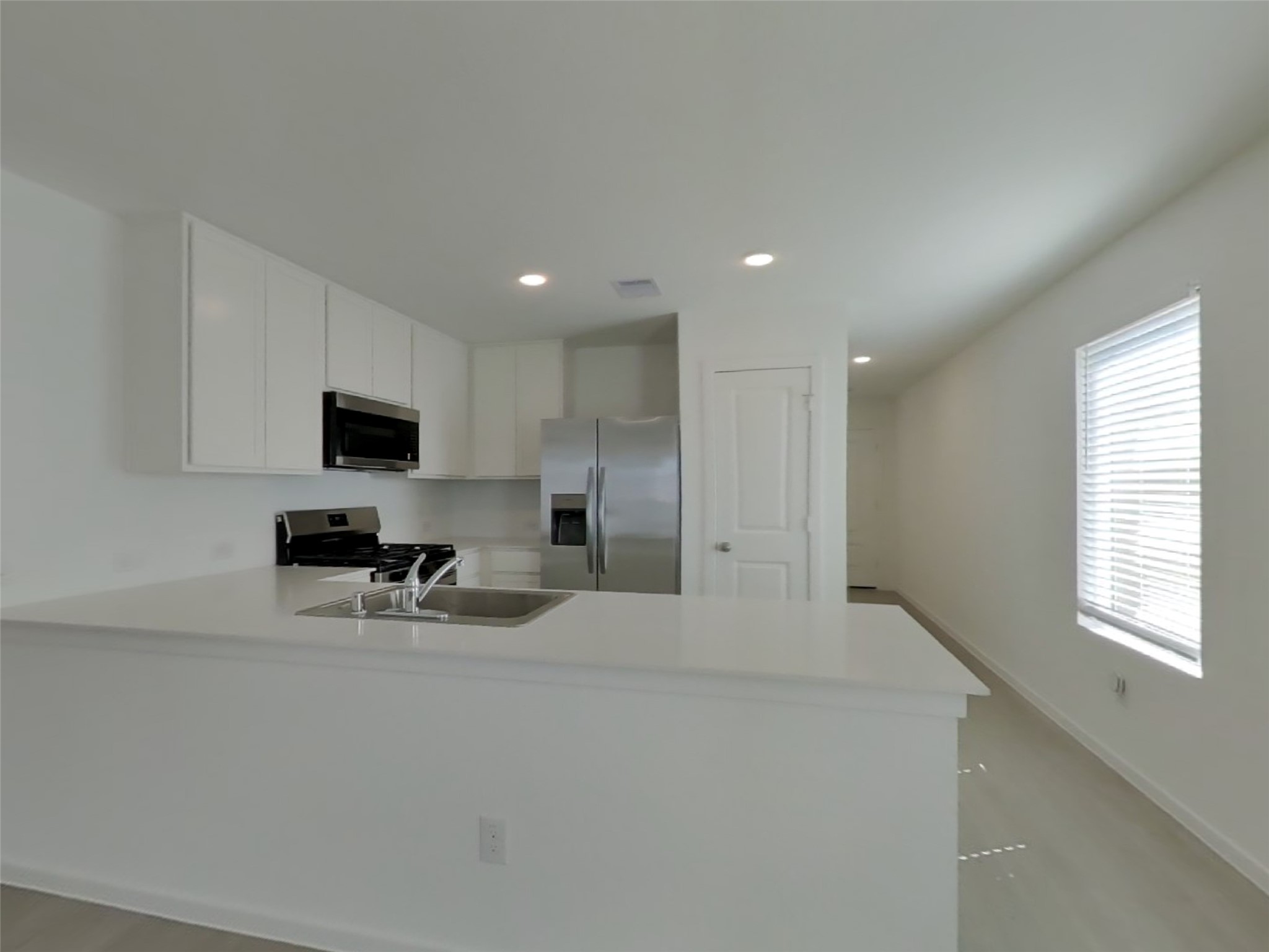 13035 Shells Lane Crosby, TX 77532 - Photo 6 of 17 a large white kitchen with stainless steel appliances a sink a stove a microwave a refrigerator and cabinets