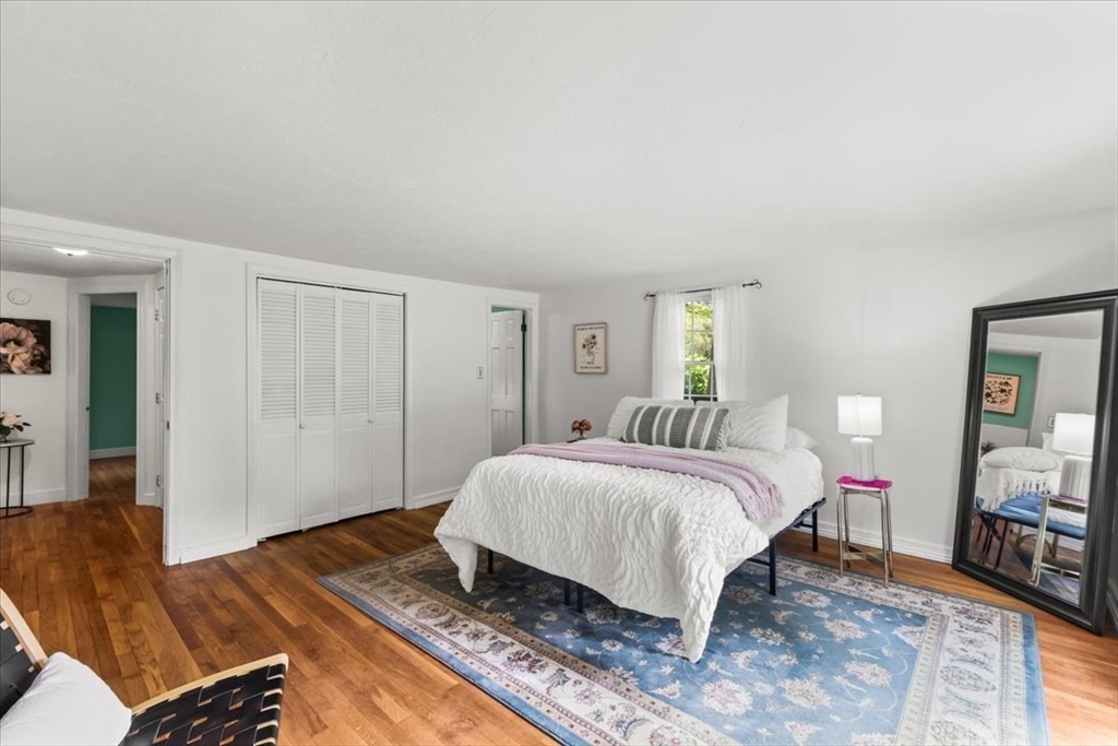 83 River Road Norfolk, MA 02056 - Photo 23 of 27 a spacious bedroom with a bed and wooden floor