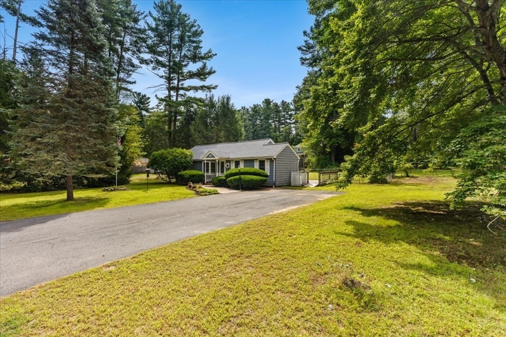 83 River Road Norfolk, MA 02056 - Photo 3 of 27 a view of a swimming pool with lawn chairs under an umbrella