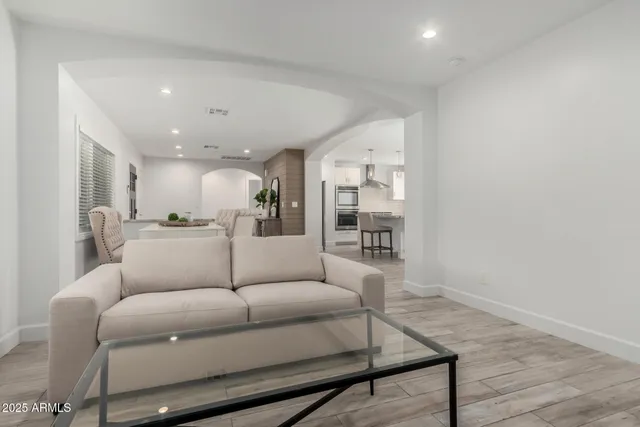 a living room with furniture and a view of kitchen
