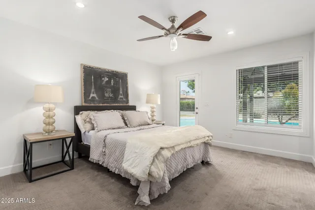 a large bed sitting in a bedroom next to a window