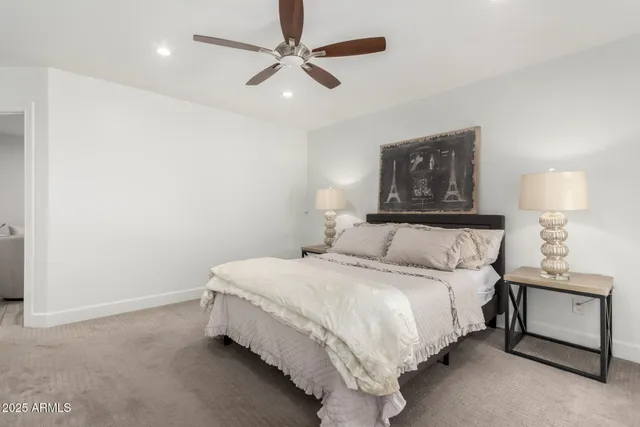 a bedroom with a bed and a lamp on a dresser