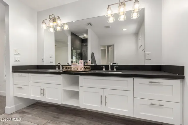 a bathroom with double sink and a mirror