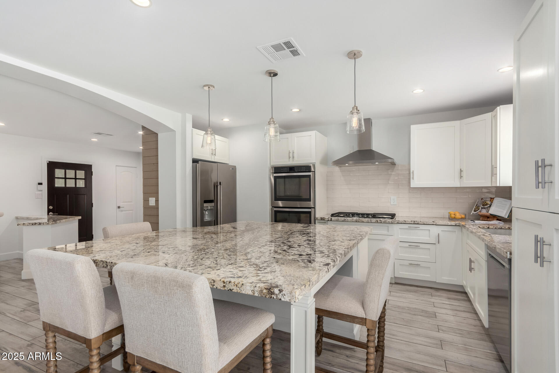 6741 North 10th Street Phoenix, AZ 85014 - Photo 6 of 37 a kitchen with granite countertop a stove a sink a kitchen island with a dining table and chairs