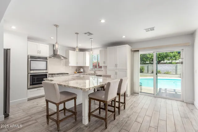 a kitchen with kitchen island a large window a sink and a refrigerator