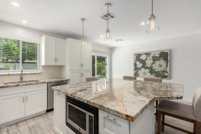a kitchen with granite countertop a sink cabinets and window